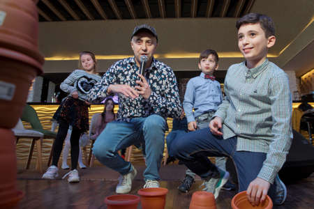 Azerbaijan Baku. 09.03.2020 . children play a race to stack a bowl on top of each other. Kids Playing with white brown cups building a cup tower on floor.のeditorial素材