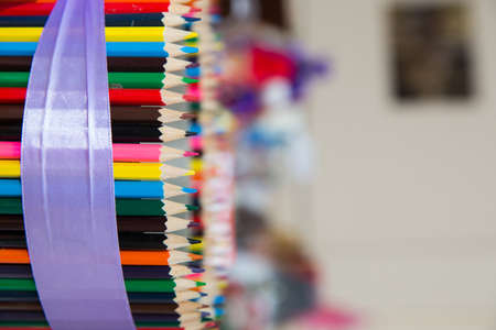 Colorful colored pencils on blurred bokeh background . Colored pencils arranged in a row and in a circle . close up of colorful set wooden color pencil in isolated black and blur background.の写真素材