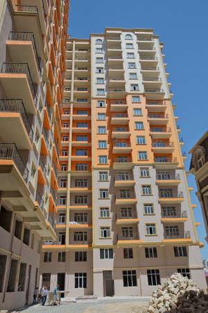 Azerbaijan Baku 04.08, 2017. Facade of modern multi-storey new residential orange building near Baku . New apartment house . Storey houses modern . High rise residential buildings under the blue skyのeditorial素材