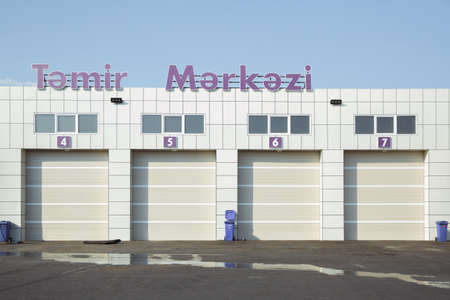 Automatic Electric Roll-up Gate Or Push-up Door In The Modern Building Ground Floor . exterior of a commercial warehouse with white roller doors .Auto - motor speedway garage . gates in the garageのeditorial素材