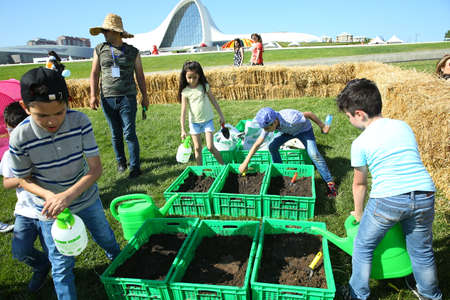 BAKU, AZERBAIJAN - JUNE 1 2019 : Kids festival . In park of Heydar Aliyev Center. Children sow seedsのeditorial素材