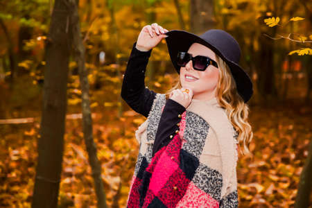 Baku Azerbaijan 21.12.2019 . photo session in the park between leaves front of the tree in autumn. The girl in black hat put black tears in her eyes . He holds his hat with his hand.のeditorial素材