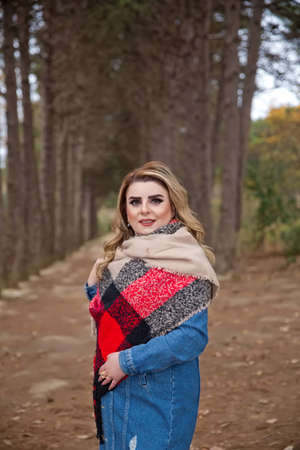 photo session beautiful girl in the park between the leaves in front of the tree in autumn . A blue girl looks at a camera and takes a picture. Baku Azerbaijan 21.12.2019 .のeditorial素材