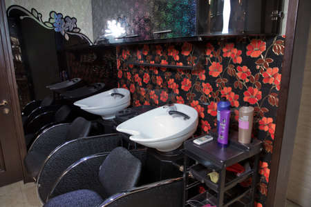 Azerbaijan Baku : 04.02.2018 . Cosmetics for hair care and other accessories in the modern beauty salon. Hairdressing equipment for washing your hair. White washbasin .chair with washbasin for a beauty salon side viewのeditorial素材