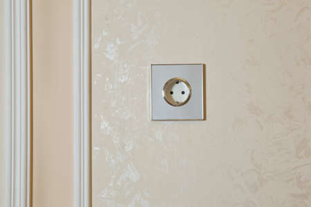 Electrical switch and plug on wall . Realistic white socket. plug white shadow rectangle wall . Green power eco white plug on white wall . Power socket in concrete wallの写真素材