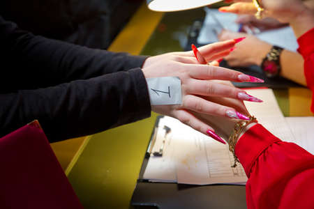 Manicure hands salon . Woman in a nail salon receiving a manicure by a beautician . Manicure process in beautiful salon . Closeup of Woman applying nail varnish to finger nailsの写真素材