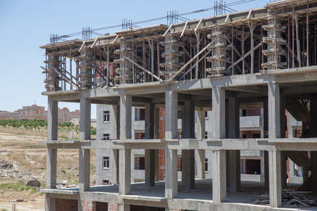 New building is being constructed with use of tower crane .Large construction site including several cranes working on a building complex, with clear blue sky .working on a construction siteの写真素材