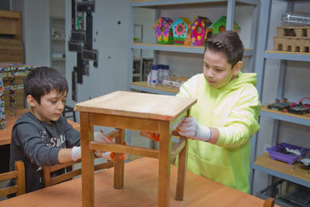 Azerbaijan Baku 17.05.2020 . Children clean to paint the top of the chair . The children paint the top of the chair.のeditorial素材