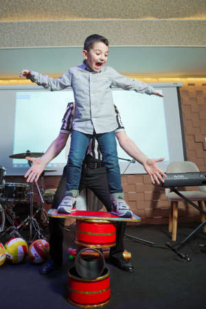 Baku, Azerbaijan - 11.03.2020 . Kids standing on top of cylinders and juggling glass bottles, one bottle broke. A series of drawings about the circus. Juggle clubs. clown riding a unicycle on a beamのeditorial素材