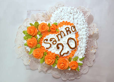 White pink heart cake . Pink Flowers on top of the cake . Samra is 20 years old . beautiful cake in the form of a heartの写真素材