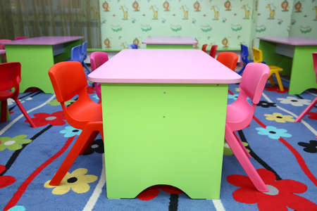refectory of a school for children with chairs and tables without people . Interior of a spacious kindergarten room with small children tables and chairs.の写真素材