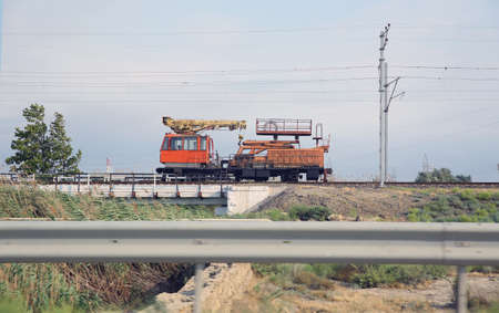 tie crane doing the railroad maintenance at train station. Crane for Railways on track it is used to clear derailments of the trains and wagons . maintenance train on the railwayの写真素材