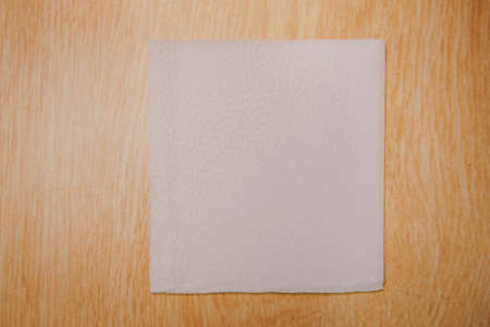White Square Bar Napkin Isolated on wooden Background . Blank paper napkin on wooden background with copy space . White napkin on wooden background, many views of white napkins, blank mockup files .の写真素材
