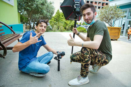 Gimbal Operator with black equipament - Stabilizer and camera filmmaking . An unidentified man holding gimbal a camera stabilizer . Man holding gimbal stabilizer outdoor.のeditorial素材