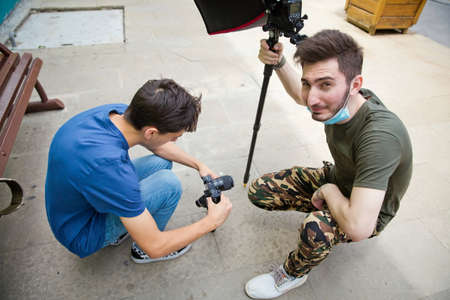 Gimbal Operator with black equipament - Stabilizer and camera filmmaking . An unidentified man holding gimbal a camera stabilizer . Man holding gimbal stabilizer outdoor.のeditorial素材