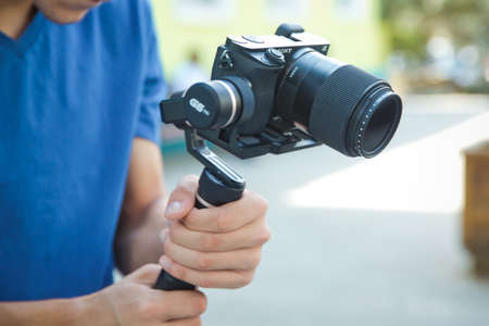 Azerbaijan baku : 26.06.2020 .Man holding gimbal stabilizer outdoor. Gimbal Operator with black equipament - Stabilizer and camera filmmaking . An unidentified man holding gimbal a camera stabilizer .のeditorial素材