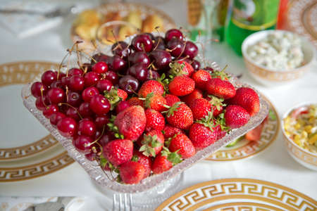 Fresh summer fruits: cherries, organic strawberries crystal bowl . Strawberries and cherries in a crystal bowl.の写真素材
