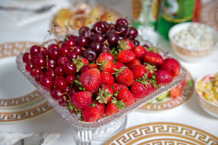 Fresh summer fruits: cherries, organic strawberries crystal bowl . Strawberries and cherries in a crystal bowl.の写真素材