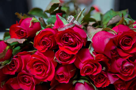 Rings on the wedding bouquet . Gold wedding rings on a bouquet of red gold flowers.の写真素材