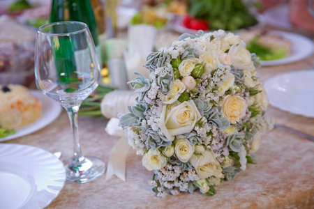 white wedding flowers in Selective focus and blurred background . Close up picture of empty glasses in restaurant . Selective focus . A bouquet of white wedding flowers on the table.の写真素材