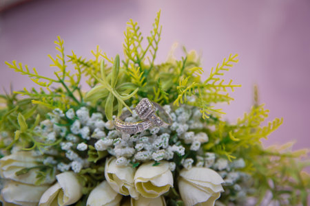 Bouquet of white roses. Gold rings for a wedding on a bouquet of flowers. White wedding rose bouquet.の写真素材