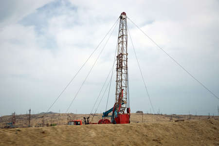 Oil and gas drilling rig onshore dessert with dramatic cloudscape . Land oil drilling rig blue sky .Land rig during the drilling operationの写真素材