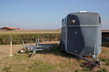 A horse trailer with graphics is ready to hook up and go . silver horse trailer on green weadow . A trailer used for transporting one adult horse A trailer used for transporting one adult horse.のeditorial素材