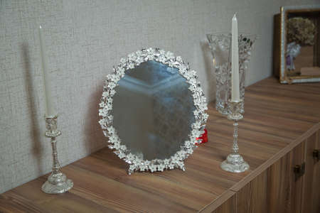 wedding mirror and candle on the table . Candle isolated on the blur background. candle in antique brass candelabrum or candlestickの写真素材