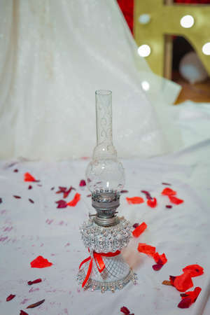 Vintage kerosene oil lantern lamp burning with a soft glow light in an antique rustic country barn with . At the wedding, the father spins his daughter three times on the lamp.の写真素材