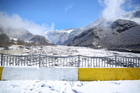 River bridge. Winter and mountains . There is fog at the foot of the mountains . It snowed on the river stones. In winter, the river water decreased . View of the river over the bridge .の写真素材