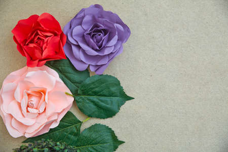 Green leaves and pink, red, blue, Artifical flower over white background. With area for copy space, text, words, graphic design. Macro detail of green leaf texture.の写真素材
