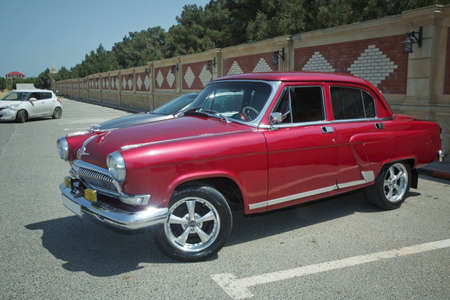 Azerbaijan, Baku. 06.06.2021: Close-up view of the old russian car GAZ-21 Volga parked in the yard. Soviet retro car from 1950s and 1960s. Vintage transport . Red famous retro transportのeditorial素材