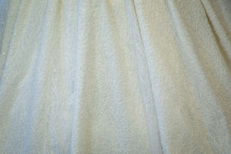 Fabric textile texture for background close-up, background to insert text or design . A close up of perfect white wedding gown of bride. bridal wear, elegant floor-length first holy communion dress.の写真素材