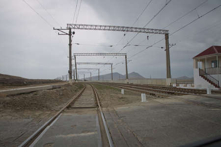 The local railway station on the rural area . Railway tracks turn to the left. Rails for the train, laid on a hill above the city, smoothly turn left. Technological background. Blue sky over the railrの写真素材