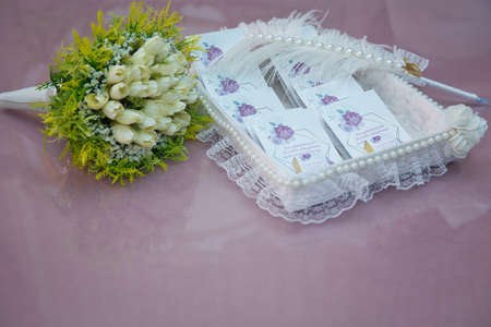 Azerbaijan, Baku . 14.11.2020 . Invitation to marriage and chocolate. A basket decorated with black pearls. A pen made of bird feathers. Freesia Koppert . Freesia Single White . White wedding bouquet .の写真素材