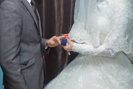 wedding rings and hands of bride and groom. young wedding couple at ceremony. matrimony. man and woman in love. two happy people celebrating becoming familyの写真素材