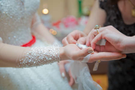 The hand of the bride is attached to the bow . The bride puts the handkerchief in her hands .の写真素材