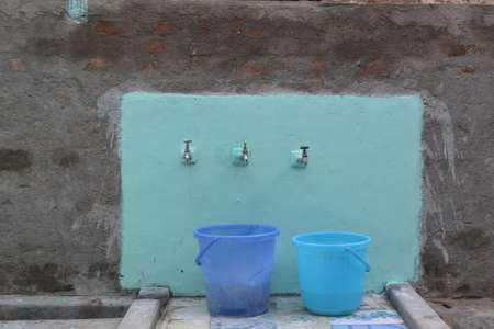 village water tabs on old wallの写真素材