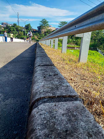 iron fence on the concrete pavement on the side of the road photoの写真素材