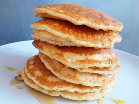 delicious pancakes on a white plate with melted honey photo