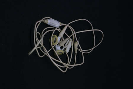 white color of earphone with messy cable photoの写真素材