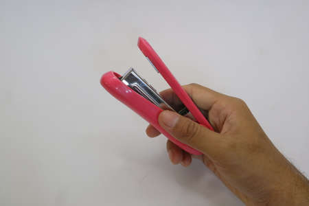 Pink color of big stapler on white isolated background photo