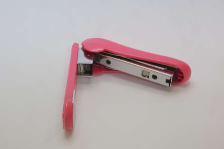 Pink color of big stapler on white isolated background photo