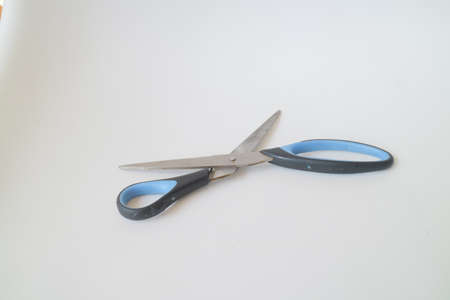 big blue and black scissors on white isolated background photoの写真素材