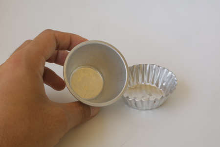 metal baking cup on white isolated background photoの写真素材
