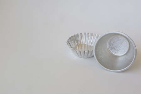metal baking cup on white isolated background photoの写真素材