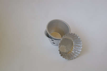 metal baking cup on white isolated background photoの写真素材