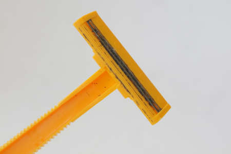 used yellow beard razor on white isolated background photoの写真素材