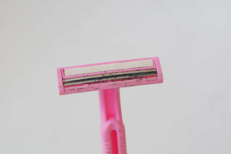 used pink beard razor on white isolated background photo