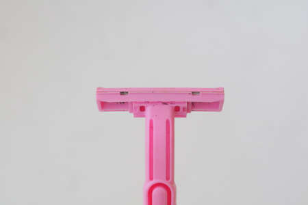 used pink beard razor on white isolated background photoの写真素材